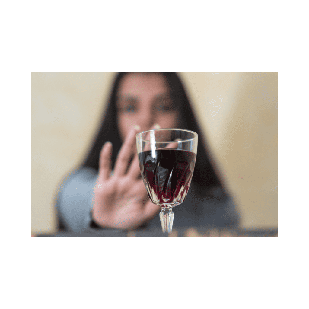 Woman raising her hand to decline a glass of wine