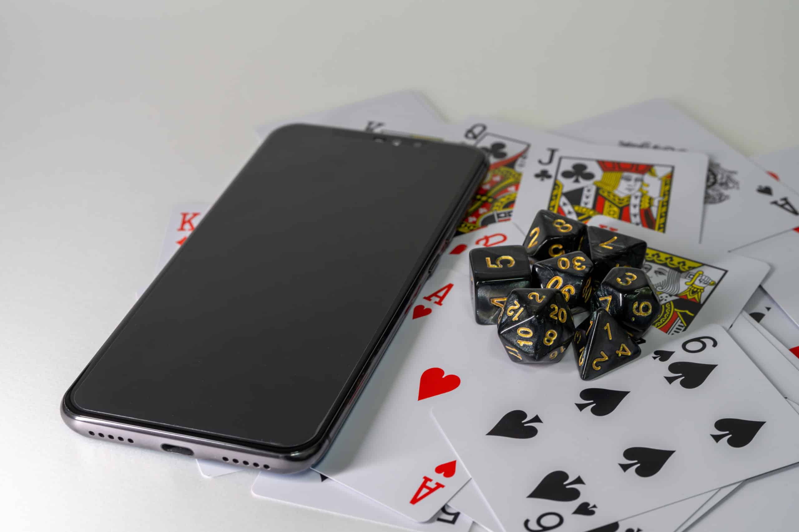 Dice, playing cards and a smartphone on a table