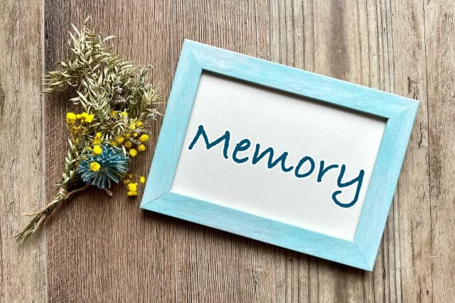 「Memory」と書かれた写真立てとドライフラワーのイメージ写真