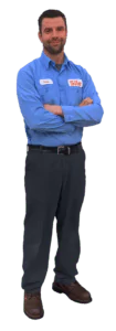 A man in a blue work shirt and dark pants stands with arms crossed, wearing brown shoes and name tags on his shirt—ready to earn top service reviews from every customer.