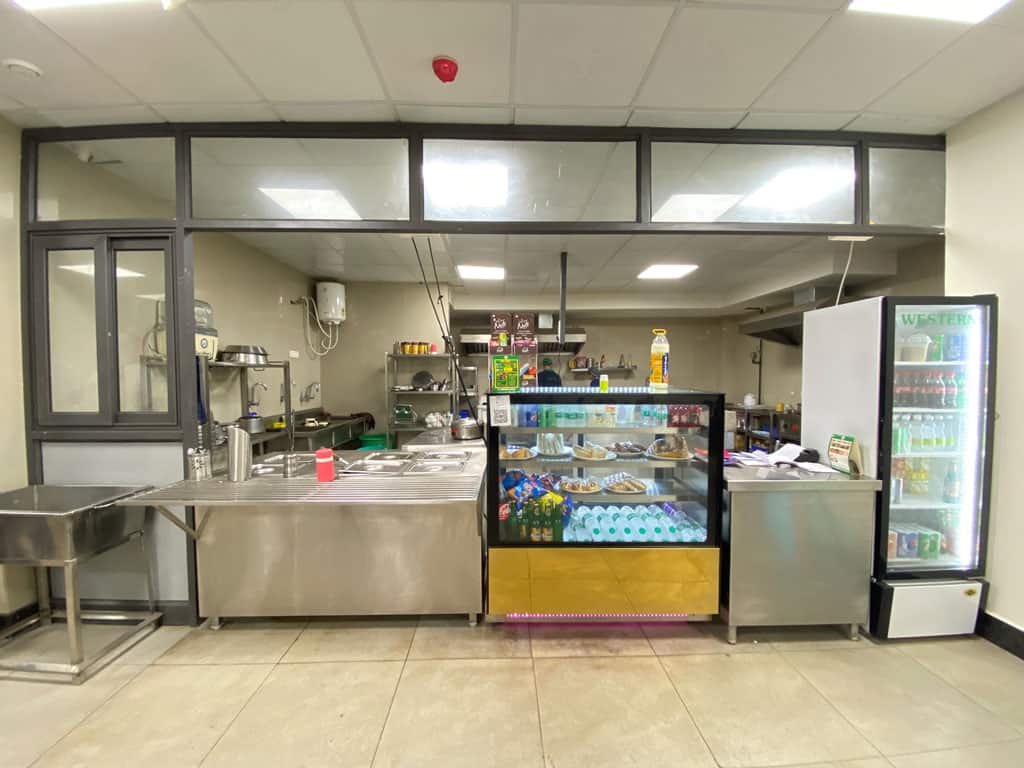Clean cafeteria food service area with refrigerated beverages and snack displays, ideal for healthy eating and hydration.