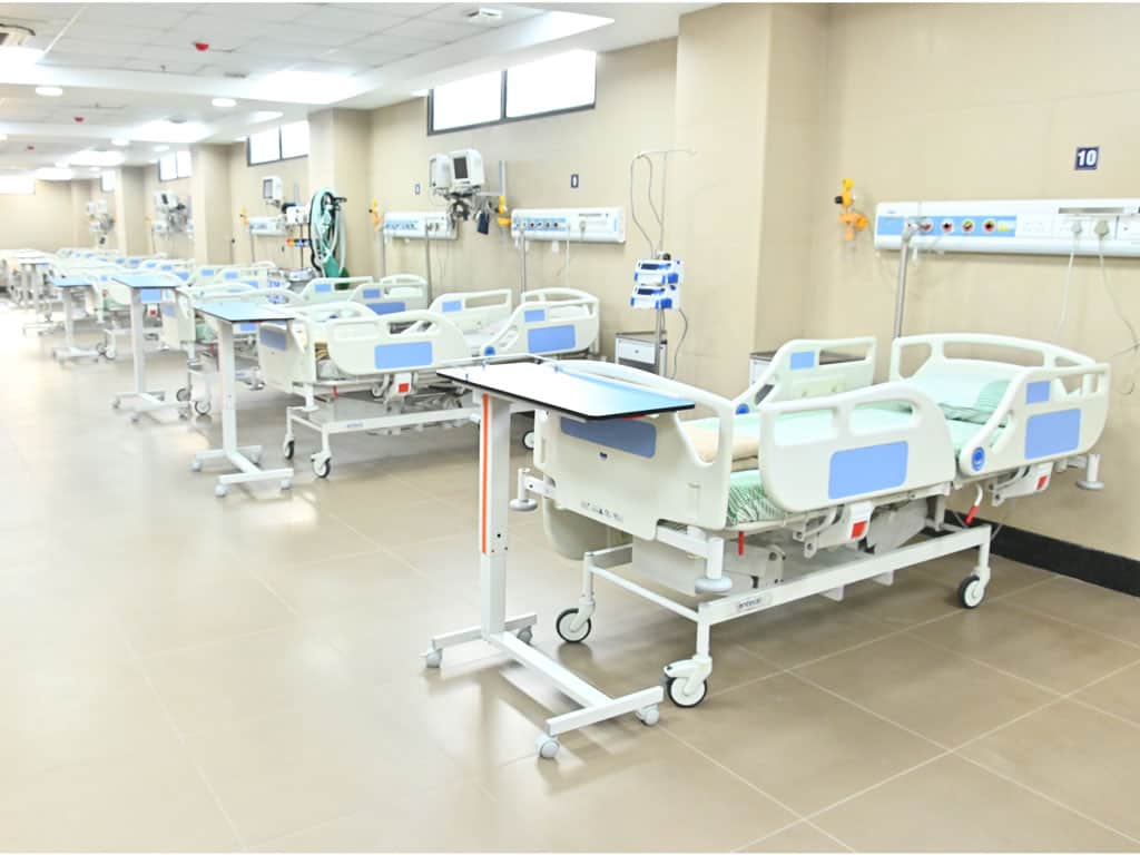 Hospital patient beds with medical equipment in a modern healthcare facility.