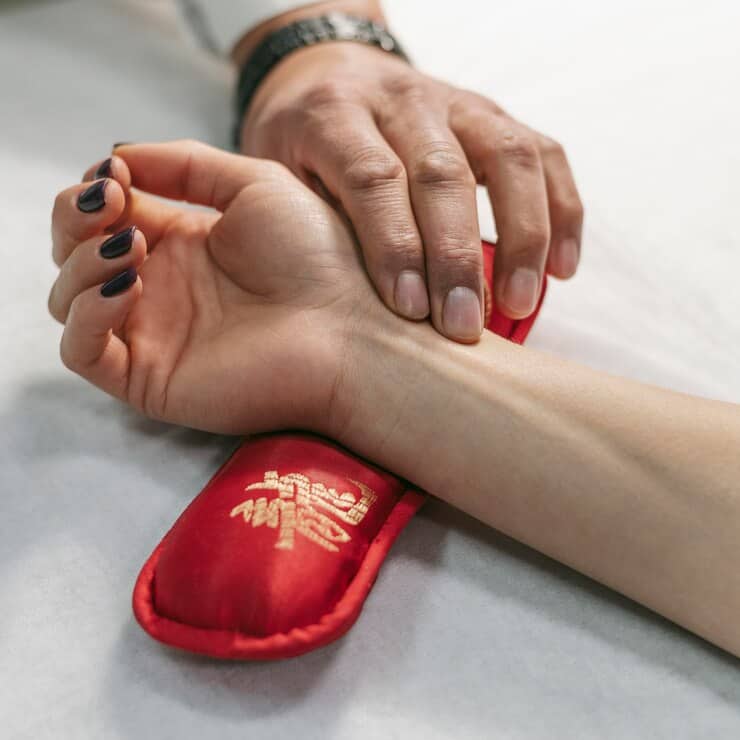Hands performing acupressure therapy at Deepak Heart Institute for holistic heart health.