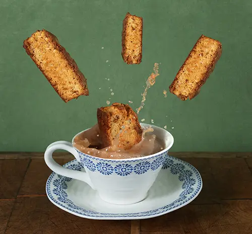 Dunking Rusks Biscotti slices falling into coffee cup with splash.