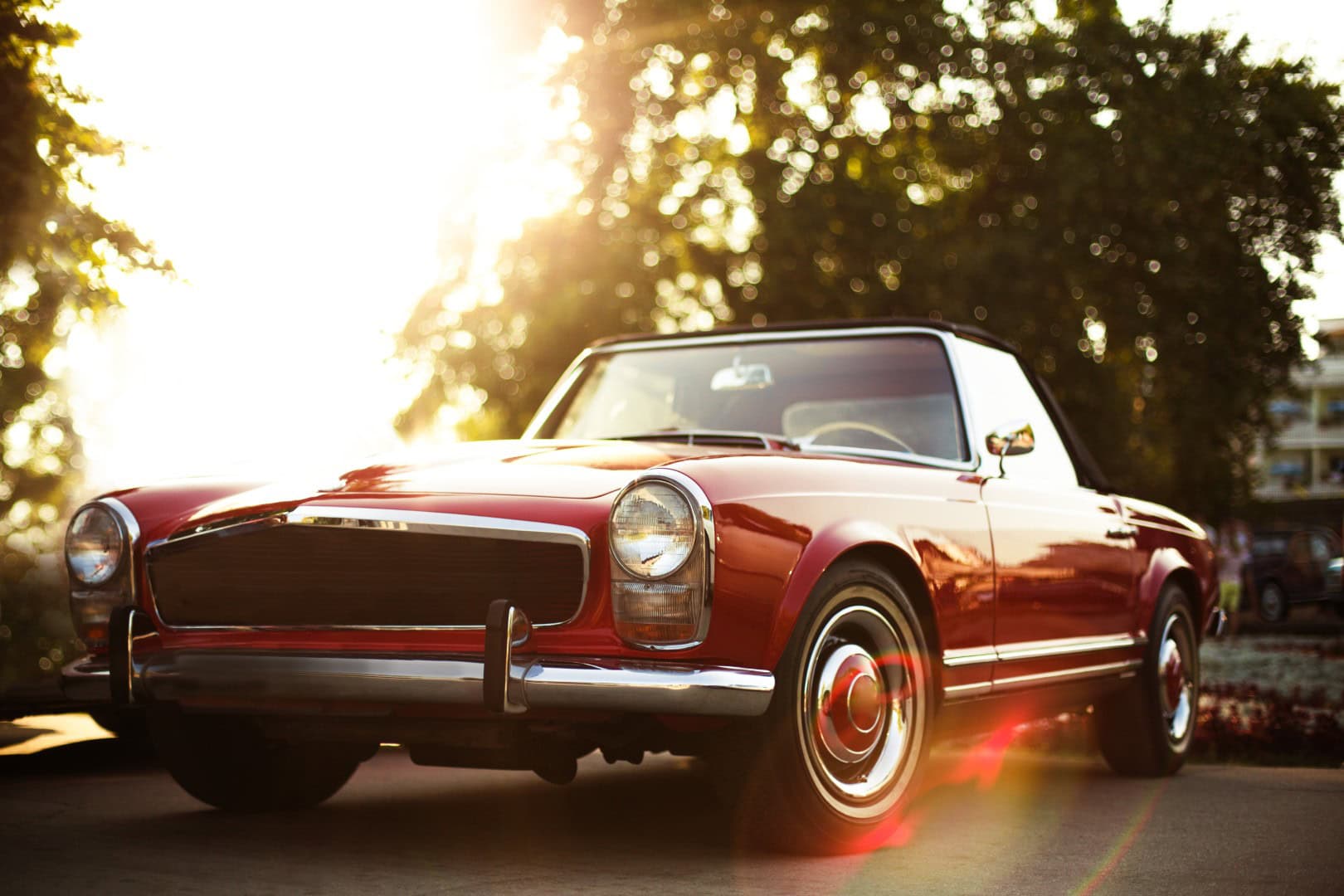 Vintage red classic car parked outdoors during sunset, highlighting timeless automotive design and the importance of regular maintenance for safety and performance.
