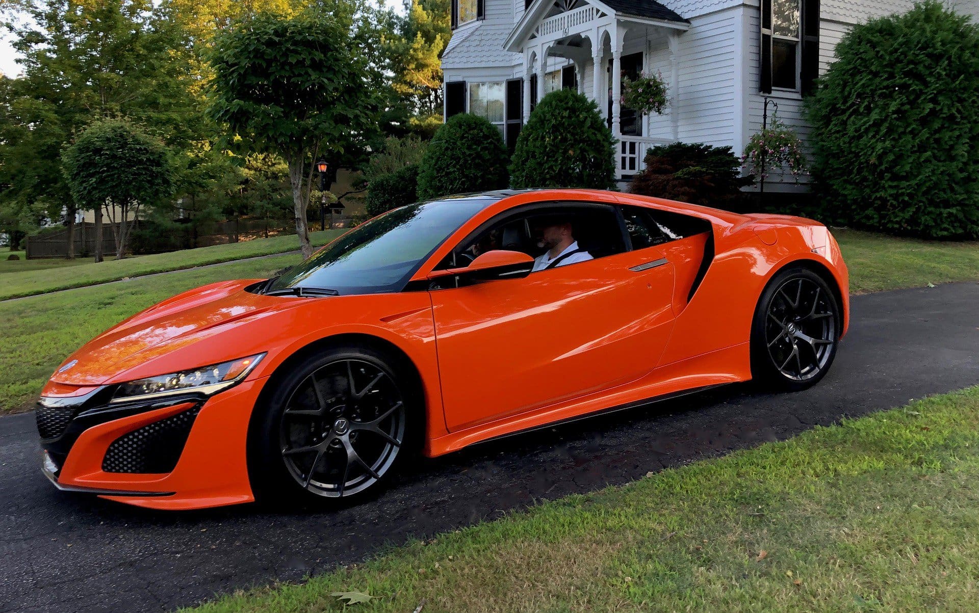 High-performance orange sports car parked on a driveway, showcasing luxury vehicle maintenance and detailing services at Del Mar Car Care.