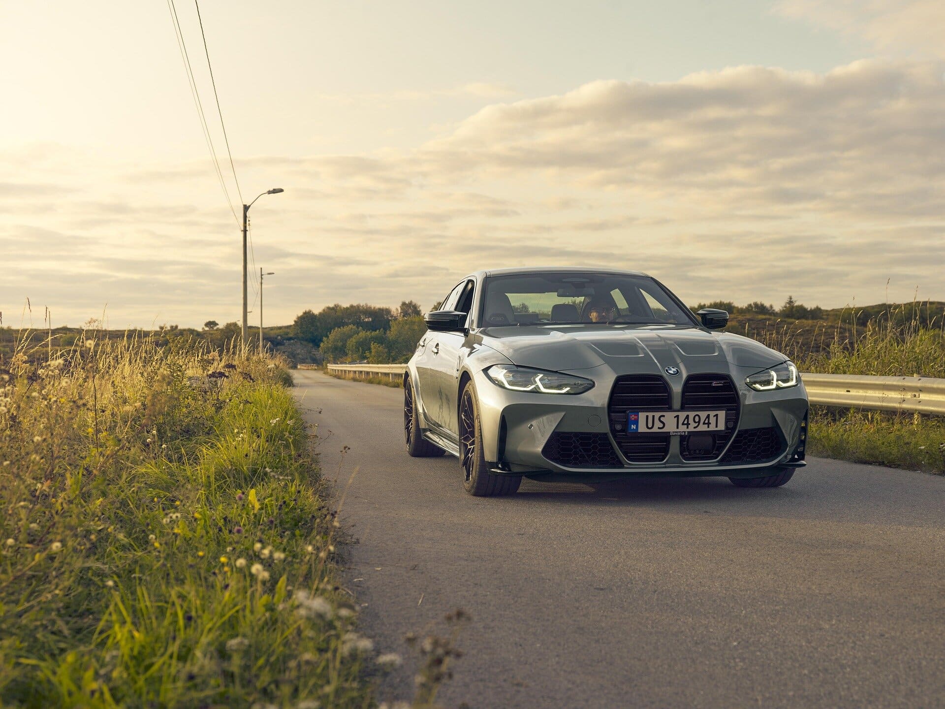 Luxury sedan on rural road at sunset, showcasing premium automotive care and quality service.