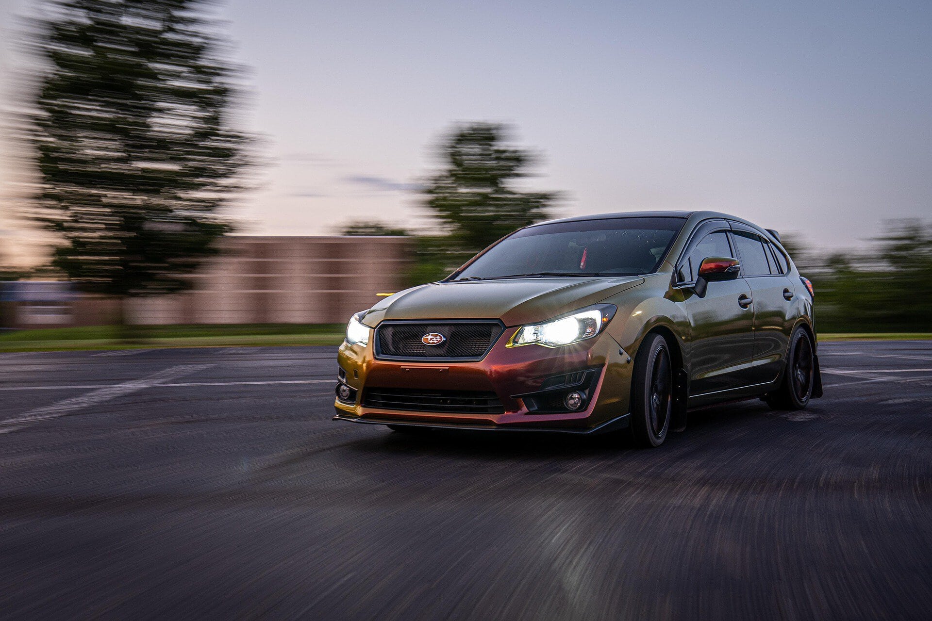 Silver Subaru Outback driving on an open road during sunset, showcasing its sleek design and reliable performance for car care and maintenance.