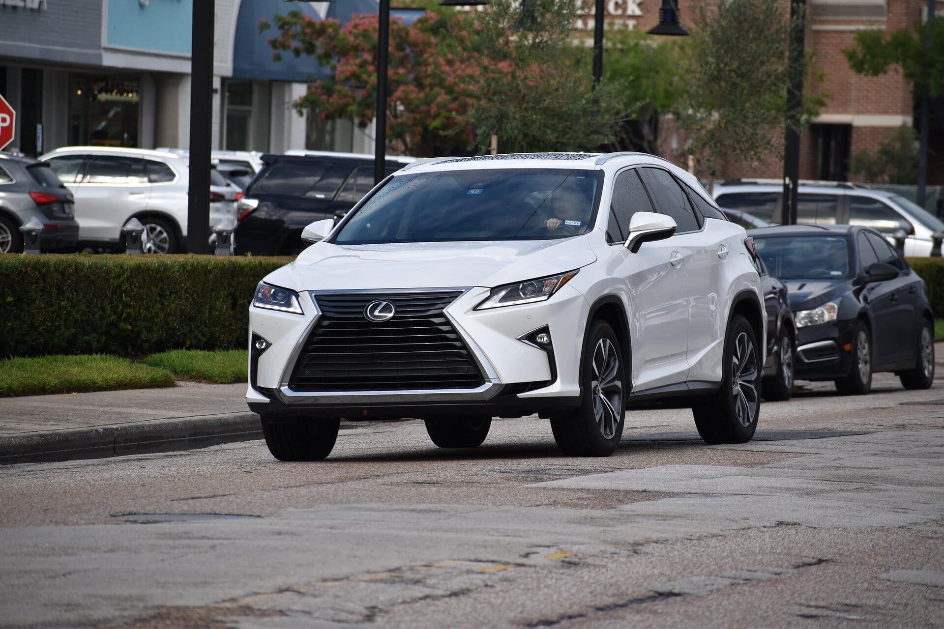Luxurious white Lexus RX SUV parked on city street in Del Mar, California. Expert auto detailing and maintenance services available for Lexus vehicles at Del Mar Car Care.