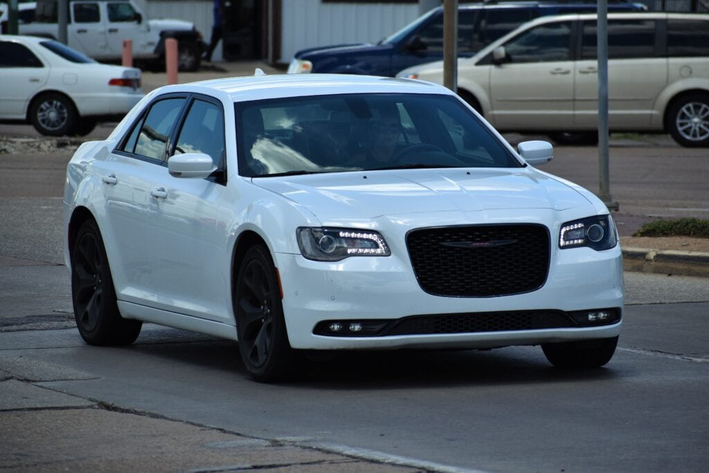 Chrysler sedan parked on the street, showcasing a sleek white exterior and modern design, ideal for vehicle maintenance and detailing services at Del Mar Car Care.