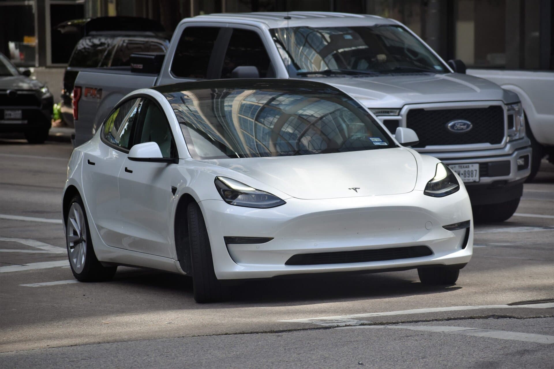 Modern Tesla Model 3 electric vehicle parked on the street, showcasing advanced EV technology and eco-friendly transportation options.