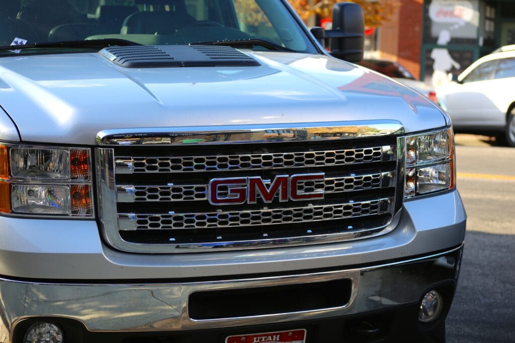 Close-up of a silver GMC truck front grille at Del Mar Car Care, showcasing professional auto repair and maintenance services for GMC vehicles.