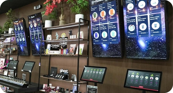 Multiple digital signage screens showcasing menu and product info in retail environment.