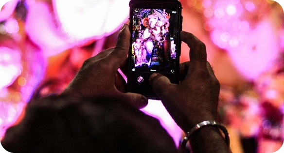 Individual capturing digital signage display with smartphone at event.