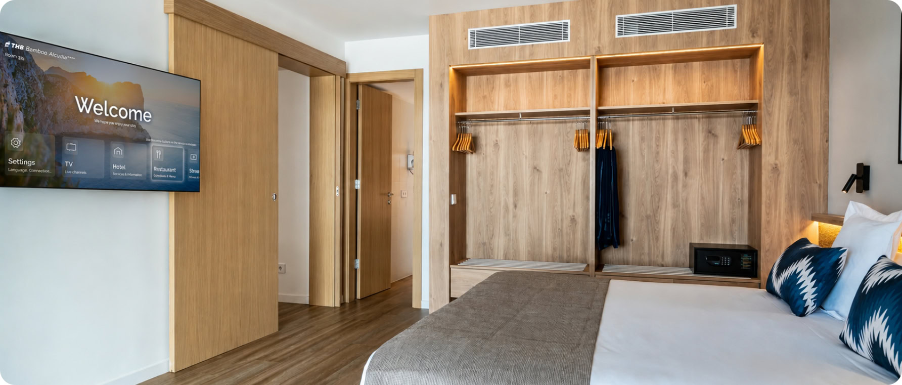 Modern hotel room with wooden accents, TV, and cozy bed at Denali Development.