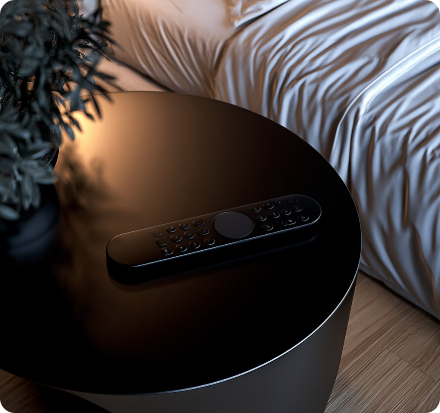 Black nightstand with remote control beside bed in modern bedroom.