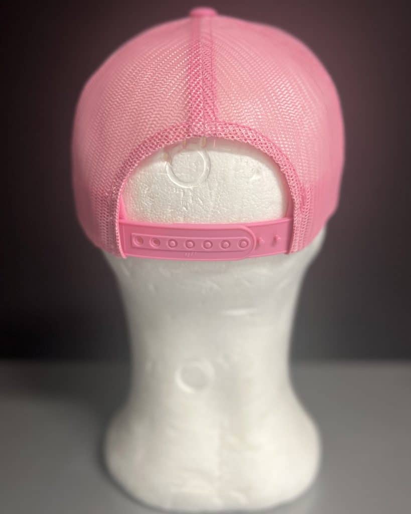 Pink mesh trucker cap with adjustable strap.