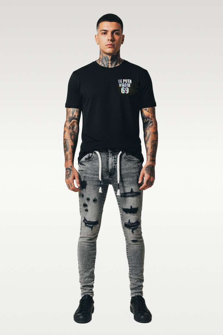 Bold streetwear model wearing De Puta Madre 69 black graphic tee and distressed jeans, urban luxury style.