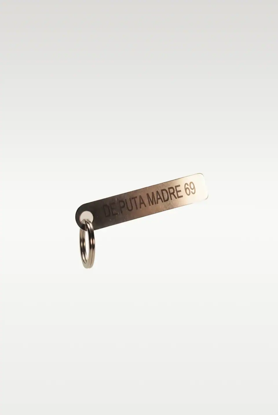 De Puta Madre 69 metal keychain with bold branding.