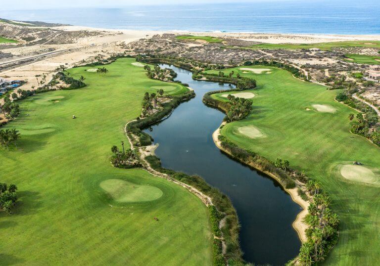 Oasis Short Course At Diamante Los Cabos With Lush Palms, Lakes, And Desert Backdrop