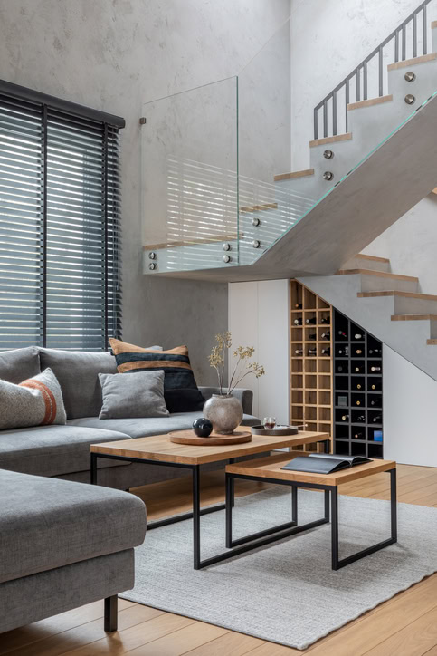 Stylish composition of living room interior with corner grey sofa, green velvet armchair, coffee table, wooden floor, design furniture and personal accessories. modern home decor. template.