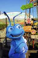 A blue mascot standing in front of a sign.