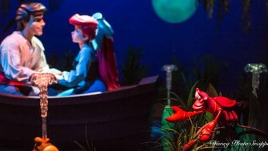 Eric and Ariel share a romantic boat ride under the moonlight as Sebastian looks on, recreating the iconic scene from The Little Mermaid.