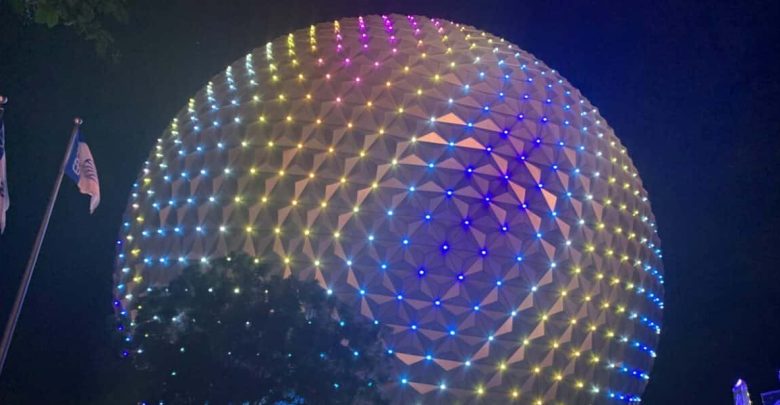 Spaceship Earth glows with vibrant lights at EPCOT, colorful flags and shady trees invite Florida residents to special ticket offers.