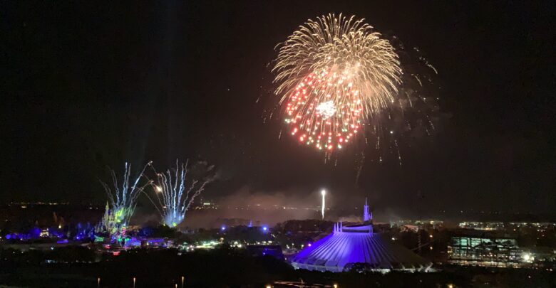 Spectacular fireworks light up the night sky above EPCOT, with Spaceship Earth glowing in dazzling white below.