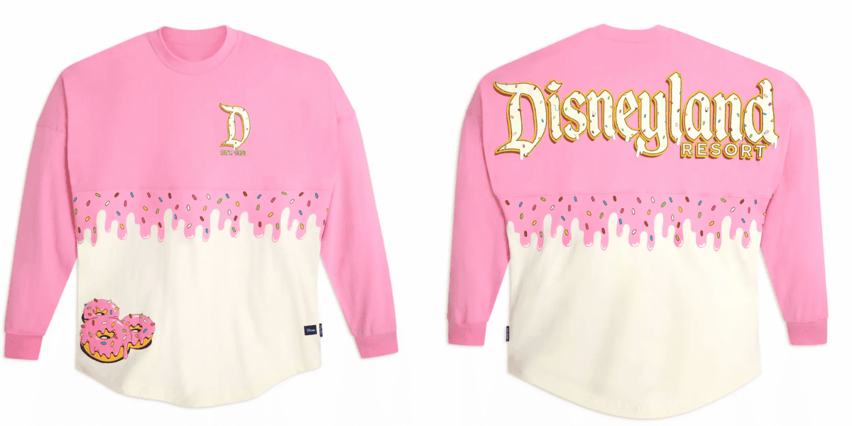 Pink and white Disneyland Resort-themed long-sleeve shirt from the Mickey Mouse Donut Collection, featuring donut illustrations. "Disneyland Resort" is written in large, golden text on the back, while the front has a smaller "D" and drippy design resembling frosting with sprinkles.
