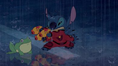 A blue alien creature wearing red armor stands in the rain, holding yellow toy guns like a character from Disney movie remakes, while a green frog sits on the wet ground. Rain creates ripples and reflections on the surface.