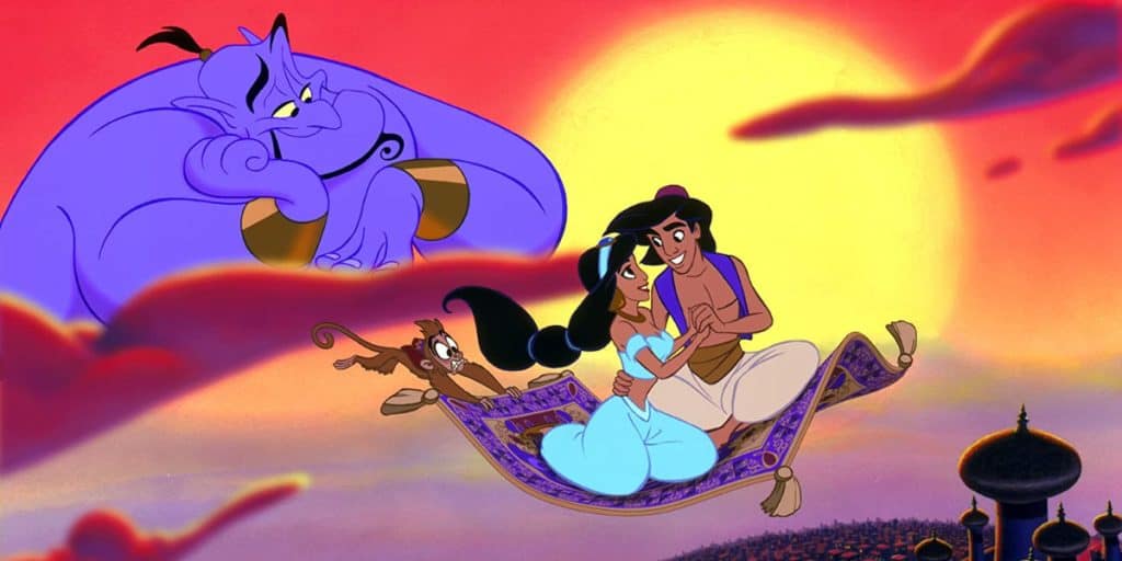 Aladdin and Jasmine sit together on a flying magic carpet at sunset, with a monkey beside them and a large blue genie smiling in the sky above—a magical scene from one of the beloved Disney movie remakes, with the city and palace visible below.