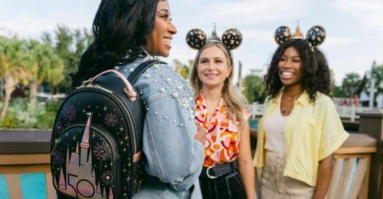 Three women at Disney with one wearing a Loungefly