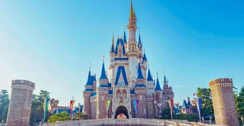 Cinderella Castle at Walt Disney World, shining under blue skies with vibrant flags, continues to dazzle guests into 2026.