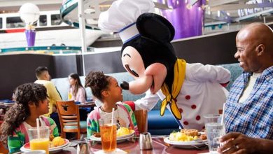 A family meets a Disney character cast member dressed as Mickey Mouse at Chef Mickey's