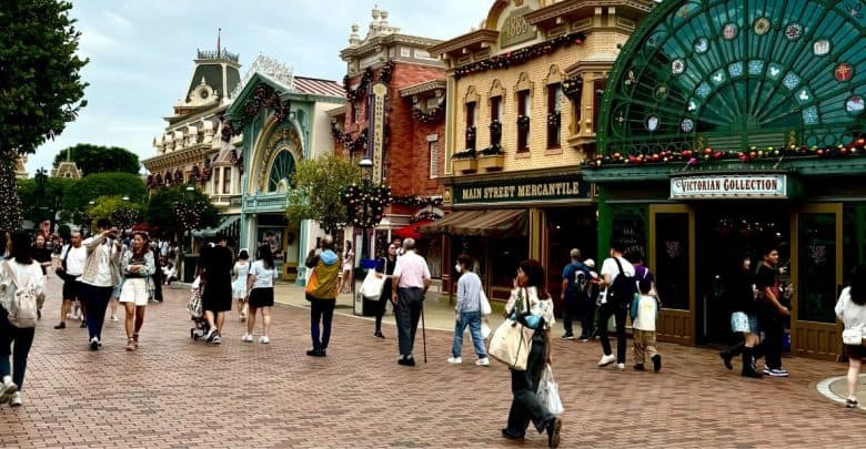 Guests wander down festive Main Street, U.S.A. at Disney Park as a service member in uniform draws admiring glances.