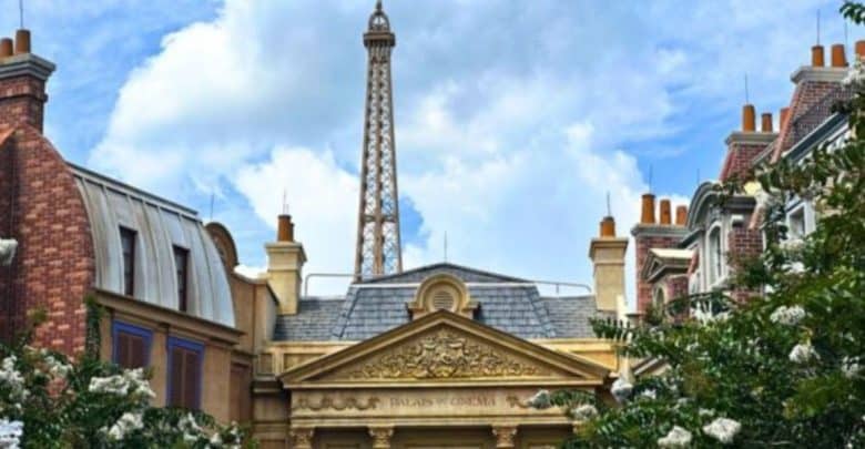 The Eiffel Tower towers above Parisian-style facades and lush trees, creating a magical backdrop like a European adventure park.