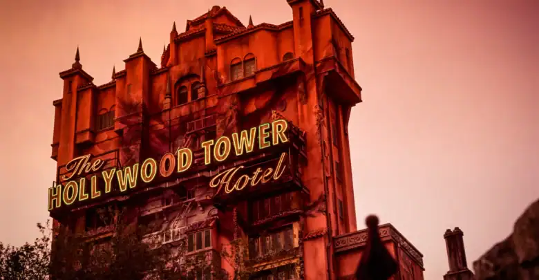 The Hollywood Tower Hotel glows with neon as twilight falls, capturing the eerie thrill of Disney's Tower of Terror at sunset.