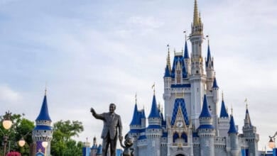Cinderella Castle majestically rises at Disney World’s Magic Kingdom, with the iconic Partners statue of Walt Disney and Mickey Mouse in the foreground, inviting guests into a world of magic and wonder—please note that some entry restrictions may apply.