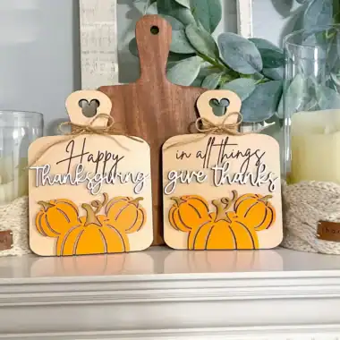 Pumpkin-themed Thanksgiving decor with wooden tags and candles for fall holidays.
