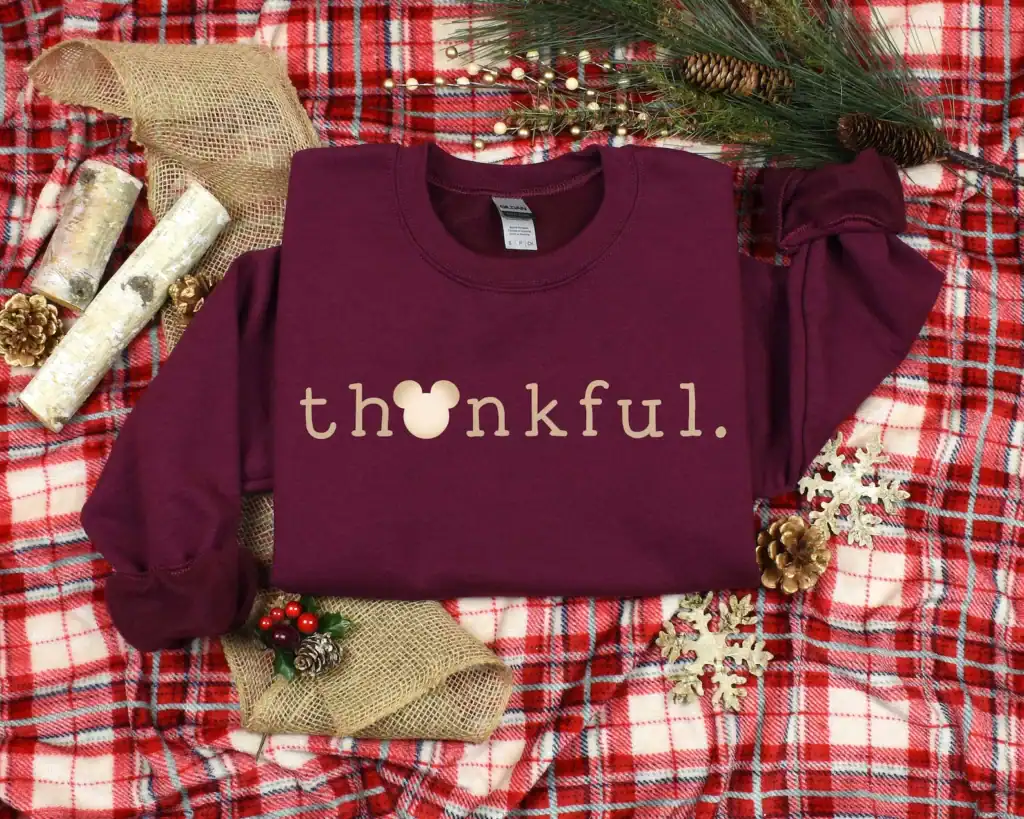 Soft burgundy sweatshirt with "thankful" text and Mickey Mouse silhouette, perfect for Disney-themed holiday fashion.