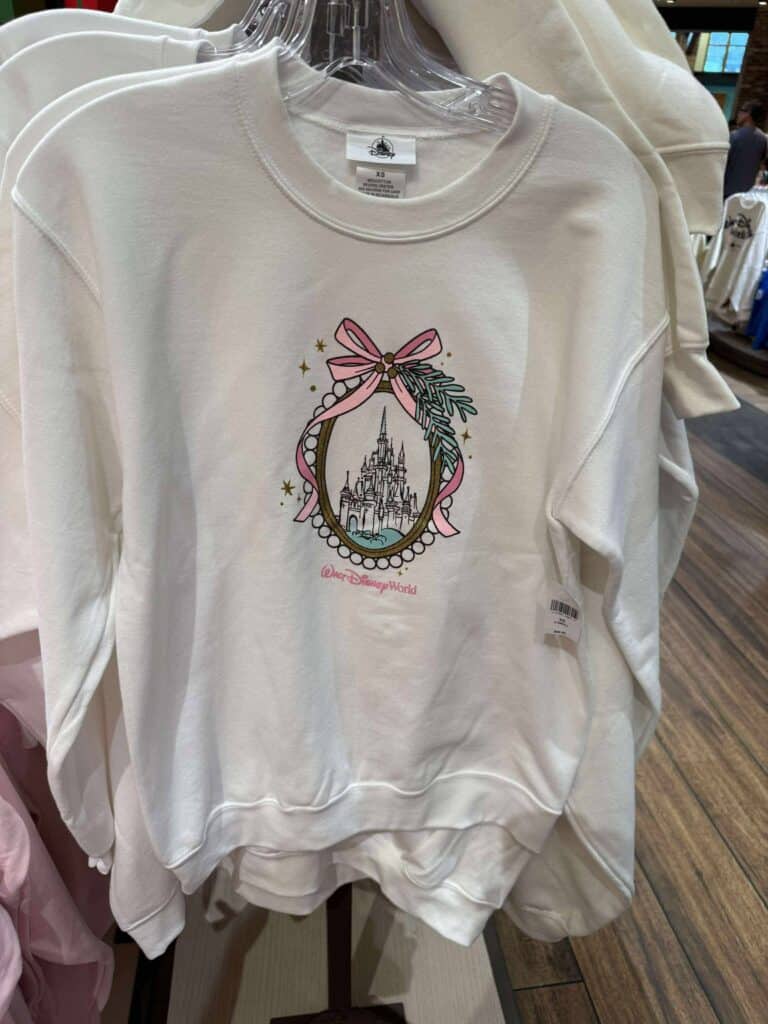 Disney Castle sweater with pink ribbon and holiday-themed embellishments.