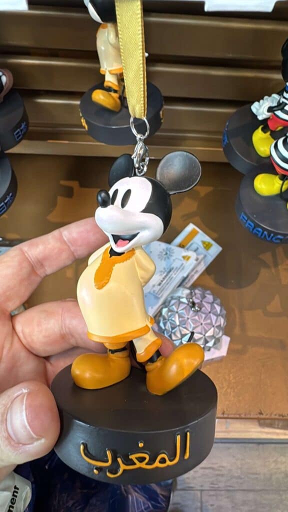 Colorful Mickey Mouse figurine keychain with orange shoes and Arabic inscription.