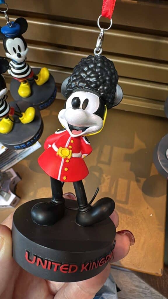 Mickey Mouse keychain featuring iconic red coat, black shoes, and curly hair, perfect Disney souvenir.