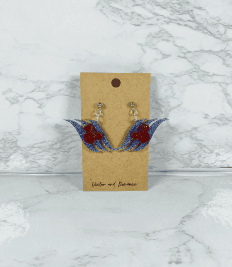 Colorful Disney-inspired blue and red bird earrings with rhinestones on a craft card.