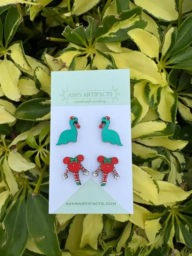 Colorful holiday themed earrings featuring a flamingo and gingerbread mouse design.