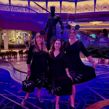 High-resolution image of three women wearing Black Panther-inspired dresses at Disney event.