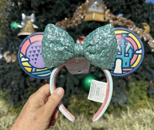 Vibrant Minnie Mouse headband with glittery teal bow, rainbow-patterned ears, perfect for Disney fashion lovers.