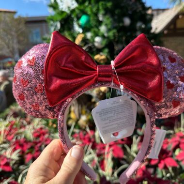 Colorful Disney Minnie Mouse ears headband with glitter pink sequins and a red bow, perfect for Disney theme park visits or holiday festivities.