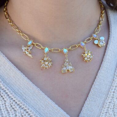Disney jewelry, charm necklace, Disney-inspired jewelry, gold chain, sparkling charms, castle pendant, floral design.